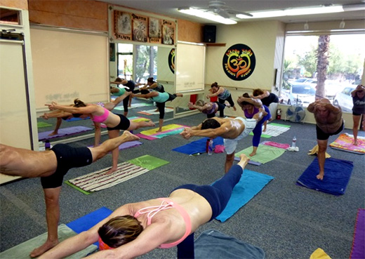Hot yoga students practicing Tuladandasana (balancing stick) pose at Bikram Yoga El Paseo.