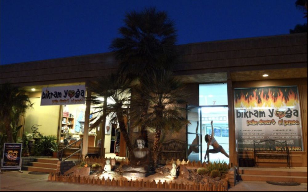 Exterior of Bikram Yoga El Paseo studio in Palm Desert with yogi posing in the doorway.